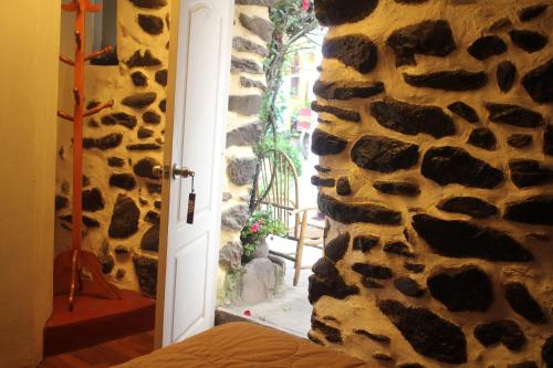 a door into a room with a stone wall at Killari B&B in Ollantaytambo