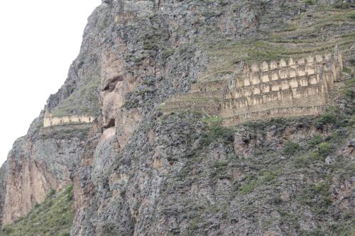 a rocky mountain with a bunch of dwellings on it at Killari B&B in Ollantaytambo