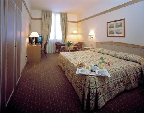 una camera d'albergo con un letto e un tavolo con cibo sopra di Grand Hotel Delle Terme Re Ferdinando a Ischia