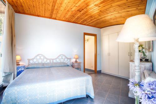 1 dormitorio con cama y techo de madera en Vela Bianca Deluxe, en Letojanni