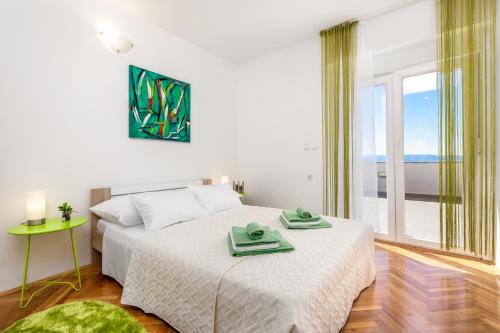um quarto com uma cama e uma grande janela em Enjoy the Silence, Nature and Sea em Kraljevica