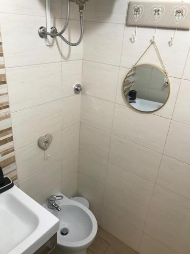 a bathroom with a toilet and a sink and a mirror at Il Casalino Apartment in Pizzo
