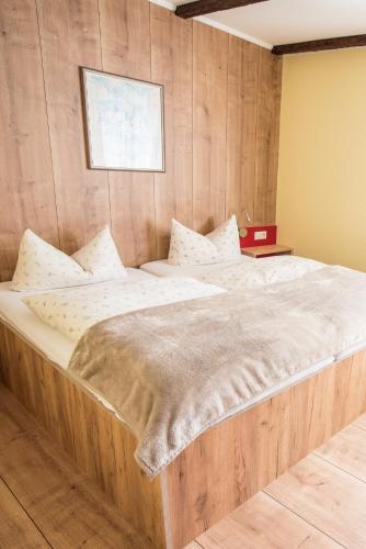 a large bed in a room with wooden walls at Hotel Schweizerhof in Böbingen an der Rems