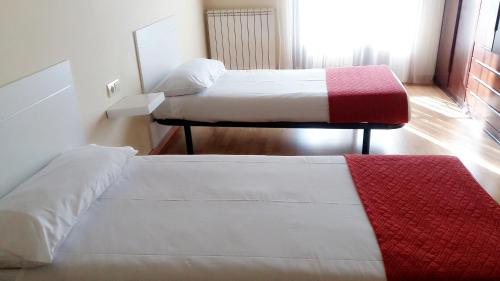 a room with two beds and a red rug at Casa Rural Claudia in Albarracín