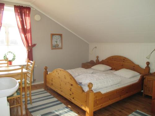 1 dormitorio con cama de madera y lavamanos en Munkebergs Stugor & Vandrarhem en Filipstad