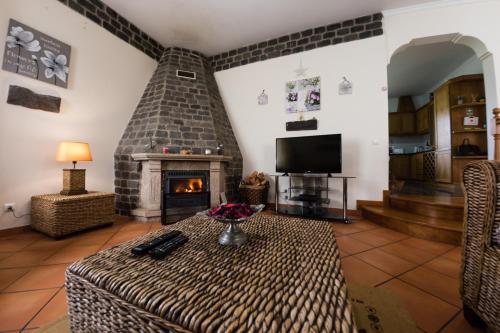 a living room with a fireplace and a table at Casa Nunes in Santana