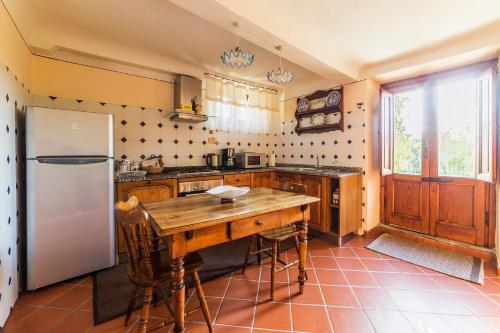a kitchen with a wooden table and a refrigerator at Casa Orsolini in Lucca