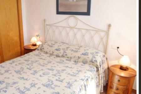 1 cama en un dormitorio con 2 lámparas en las mesas en Apartamento en Nerja, en Nerja