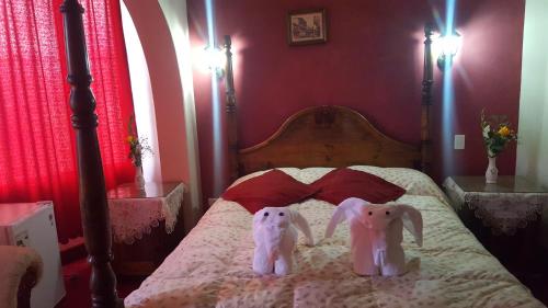 two stuffed animals are sitting on a bed at Hostal La Magia de Uyuni in Uyuni