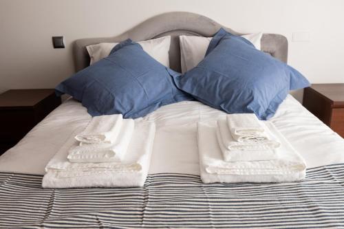 Apartamento Arrabida في لشبونة: سرير عليه وسائد ومناشف زرقاء