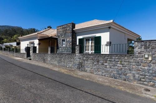 a stone retaining wall in front of a house at Casa Nunes in Santana