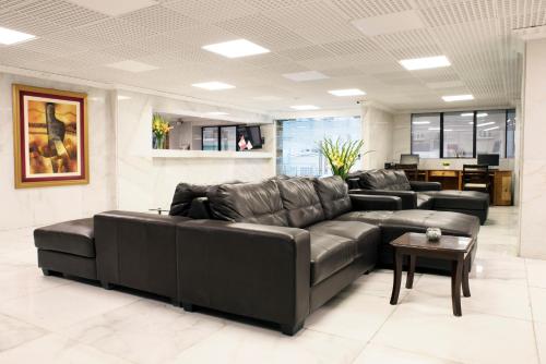 a living room with a leather couch and a table at Inkari Apart Hotel in Lima