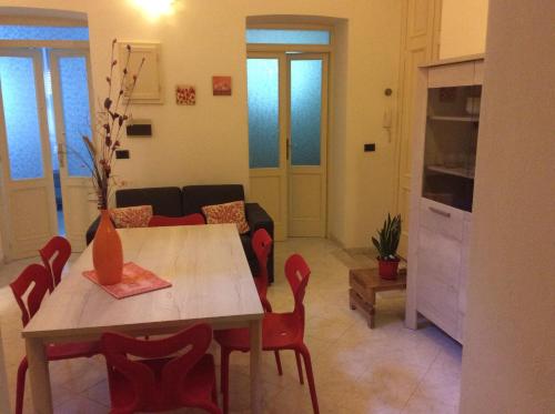 a living room with a table and red chairs at Alloggio privato Giunic in Cagliari