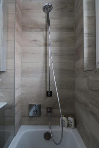 La salle de bains est pourvue d'une baignoire et d'une douche. dans l'établissement Apartment Roccabella, à Davos