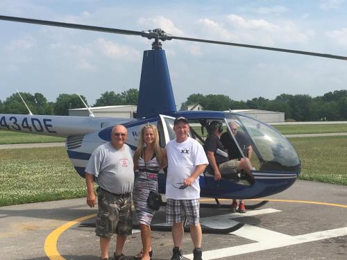a group of people standing in front of a helicopter at Island Club #71 in Put-in-Bay