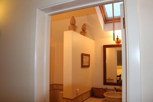 La salle de bains est pourvue d'un lavabo et d'un miroir. dans l'établissement Luxury VILLA CAMÉLIA. Mountains, golf, horses, levada walks., à Santo da Serra