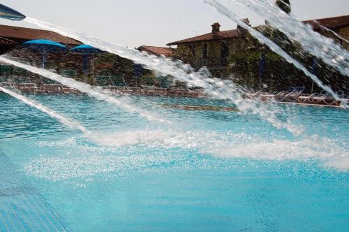 a water fountain in the middle of a swimming pool at Residence La Margherita in Lazise