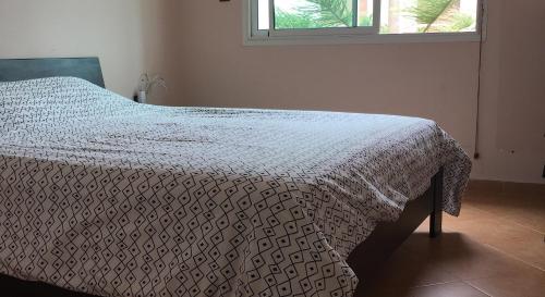 Un dormitorio con una cama con una manta blanca. en Maison Naila, en El Jadida