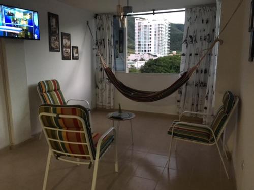 sala de estar con 2 sillas y TV en Apartamento En el Rodadero, en Santa Marta