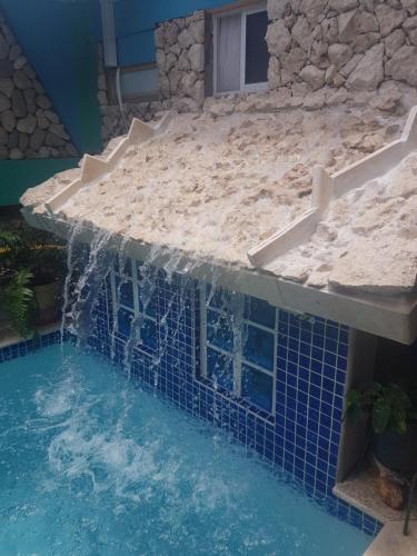 a swimming pool with a waterfall in a house at A1 Apartments Aruba in Oranjestad