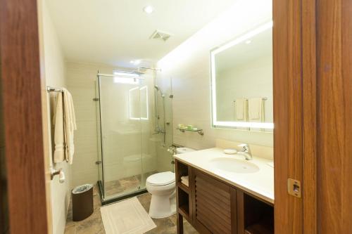 a bathroom with a toilet and a sink and a shower at Surfrider Resort Hotel in Saipan