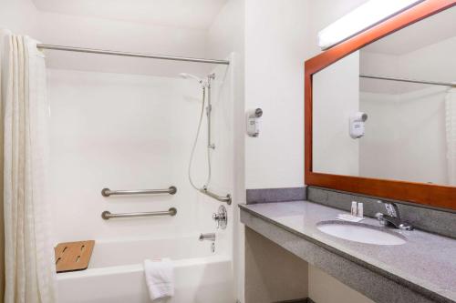 La salle de bains est pourvue d'un lavabo, d'une baignoire et d'un miroir. dans l'établissement Creekside Inn & Suites, à Willits