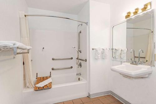 a white bathroom with a sink and a shower at Days Inn by Wyndham Espanola in Espanola