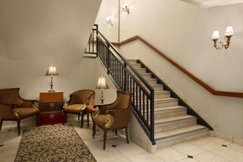 a hallway with stairs and chairs and a stair case at Travelodge by Wyndham Strathmore in Strathmore