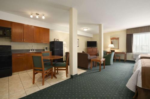 a hotel room with a kitchen and a living room at Travelodge by Wyndham Strathmore in Strathmore