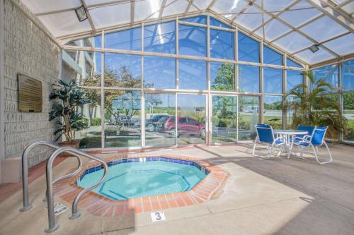 a hot tub in a glass house with a table and chairs at Baymont by Wyndham Corbin in Corbin