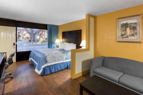 a hotel room with a bed and a couch at Days Inn & Suites by Wyndham Port Richey in Port Richey