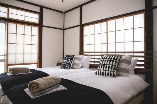 Een bed of bedden in een kamer bij Shiro Cottage