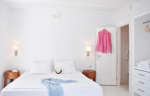 a white bedroom with a white bed and a pink dresser at Casa Montzo boutique hotel in Katelios