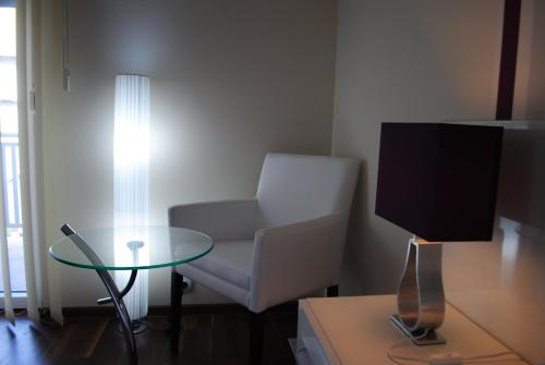 a living room with a chair and a glass table at Vila DeLux in Negotin