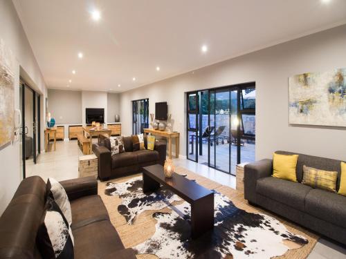 a living room with couches and a table at The Greens Guest House in Knysna