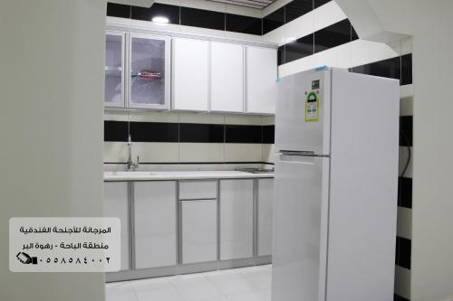 a kitchen with white cabinets and a refrigerator at المرجانة للشقق المفروشه للعائلات Al Murjana Furnished Apartments for Families in Al Baha