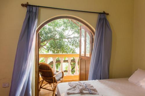 a bedroom with a bed and a large window at Villa Emmanuel 1BHk Holiday Homes in Candolim