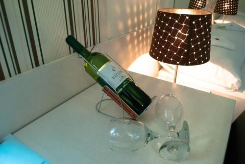 a bottle of wine sitting on a table with glasses at Vila DeLux in Negotin