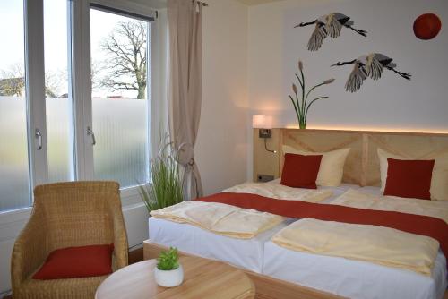 a bedroom with a bed and a table and a window at Alago Hotel am See in Cambs