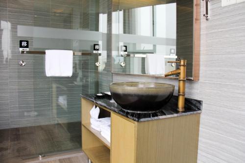 a bathroom with a bowl sink and a shower at Chambery Hotel in Zhuhai