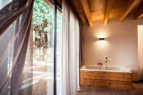 a bathroom with a tub and a large window at Hotel Villa Retiro in Xerta