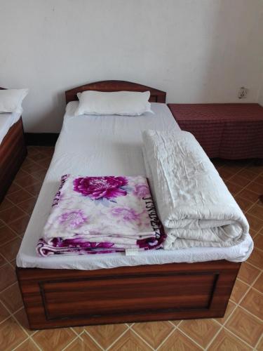 a bed with a white mattress with a blanket on it at kayastha restaurant & lodge in Bandīpur