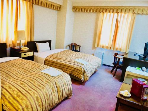 a hotel room with two beds and a desk at Business Green Hotel Hino in Hino