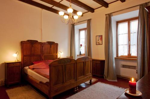 a bedroom with a wooden bed and two windows at Charming B&B and Osteria La Crisalide in Meride