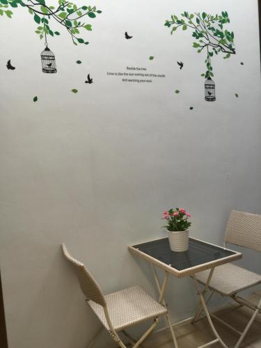 a table and chairs in a room with birds on a wall at Summerle No.11 in Chaozhou