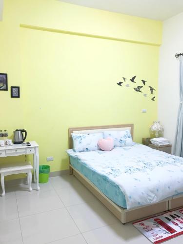 a bedroom with a bed with birds on the wall at Summerle No.11 in Chaozhou