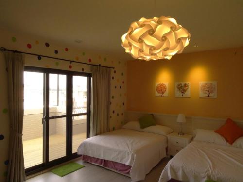 a bedroom with two beds and a chandelier at Summerle No.11 in Chaozhou