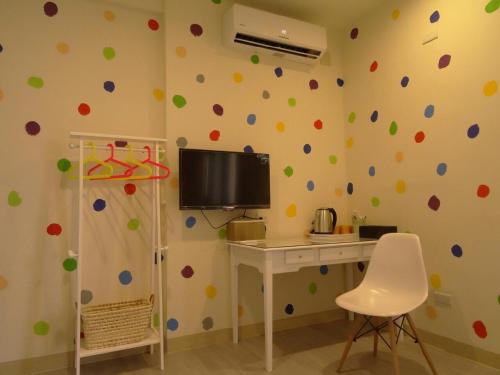 a room with a computer desk and a wall with polka dots at Summerle No.11 in Chaozhou