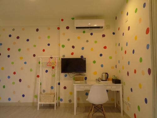 a room with a computer desk and a wall with polka dots at Summerle No.11 in Chaozhou