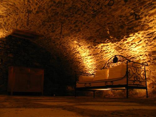 a bed in a dark room with a stone wall at Le Coffret in Saint Marcel